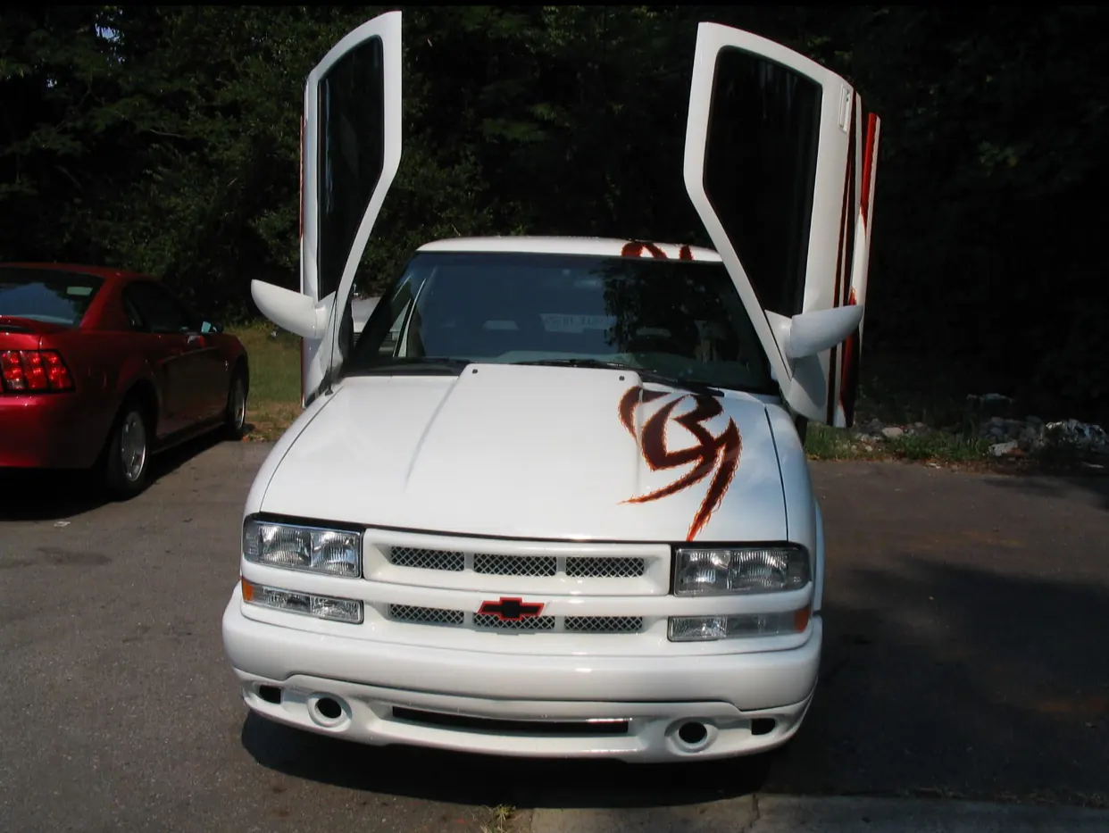 White custom Chevrolet truck with vertical doors open